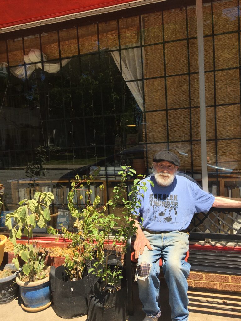 Al poses on a bench with his plants.