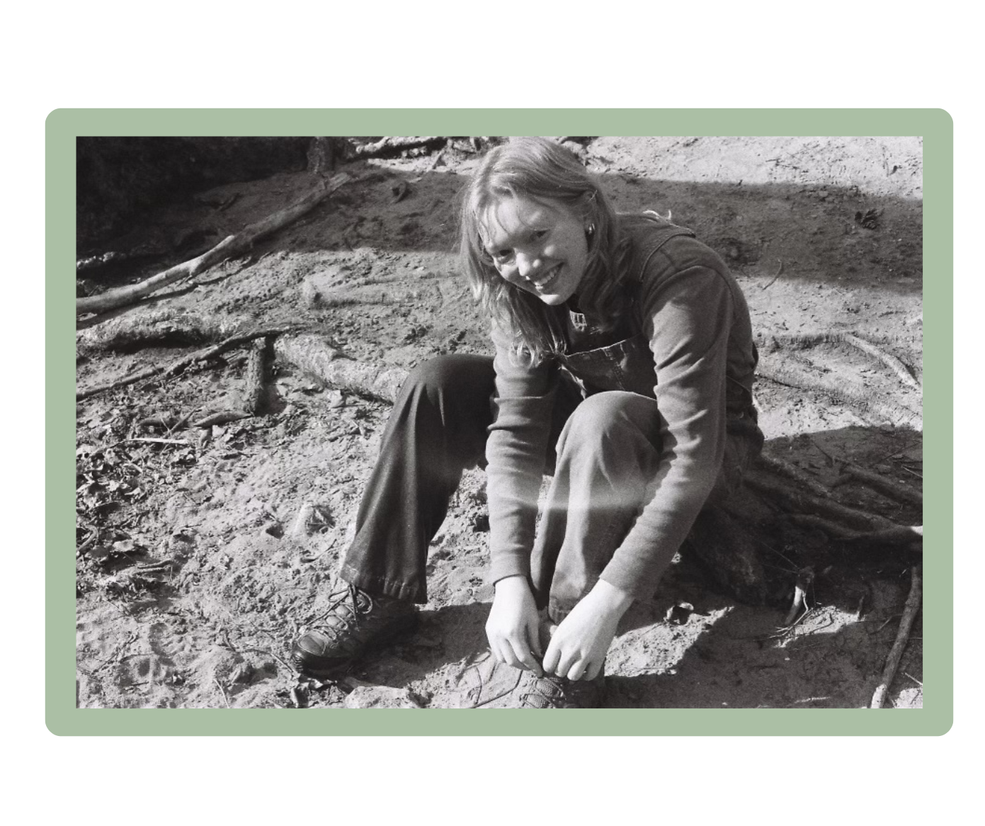 Eliza smiles at the camera as she ties her shoe.